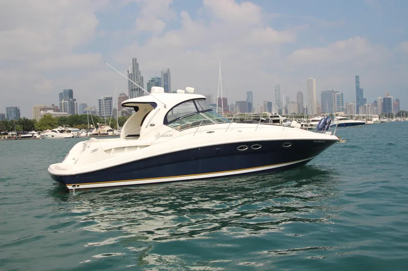 Slide: The Image of 2004 Sea Ray 40 Sundancer yacht on water with city skyline in background. - 1