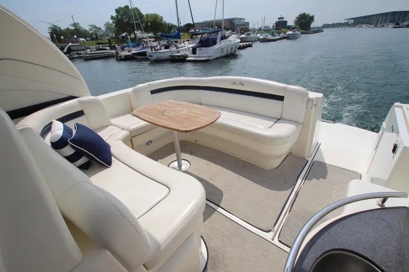 Slide: The Image of 2004 Sea Ray 40 Sundancer yacht with elegant seating and table, docked at marina. - 13