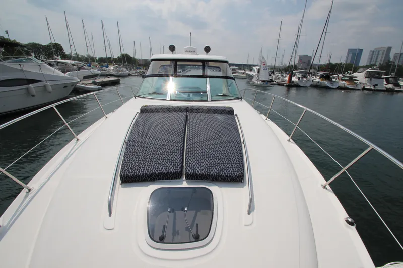 Slide: The Image of 2004 Sea Ray 40 Sundancer yacht docked in marina, featuring sun pads and sleek design. - 18