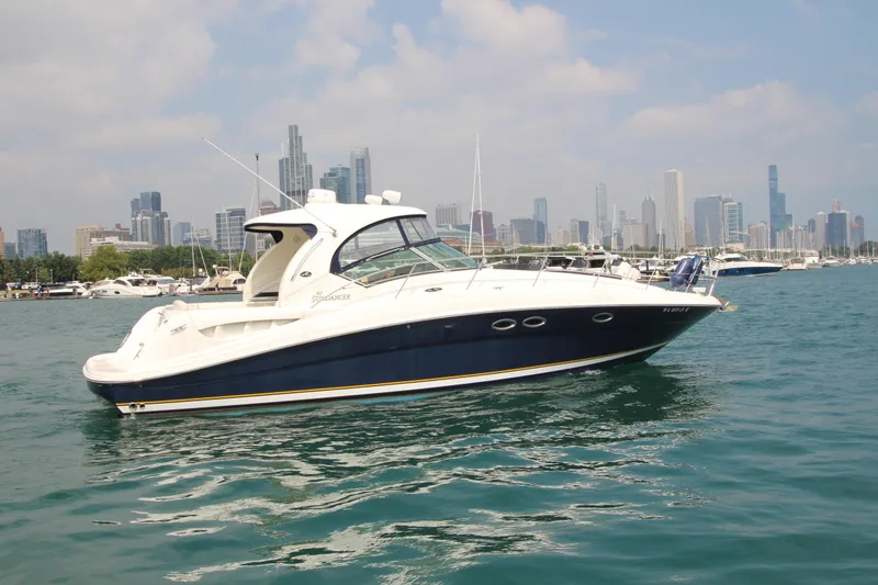 Slide: The Image of 2004 Sea Ray 40 Sundancer yacht on water with city skyline in background. - 2