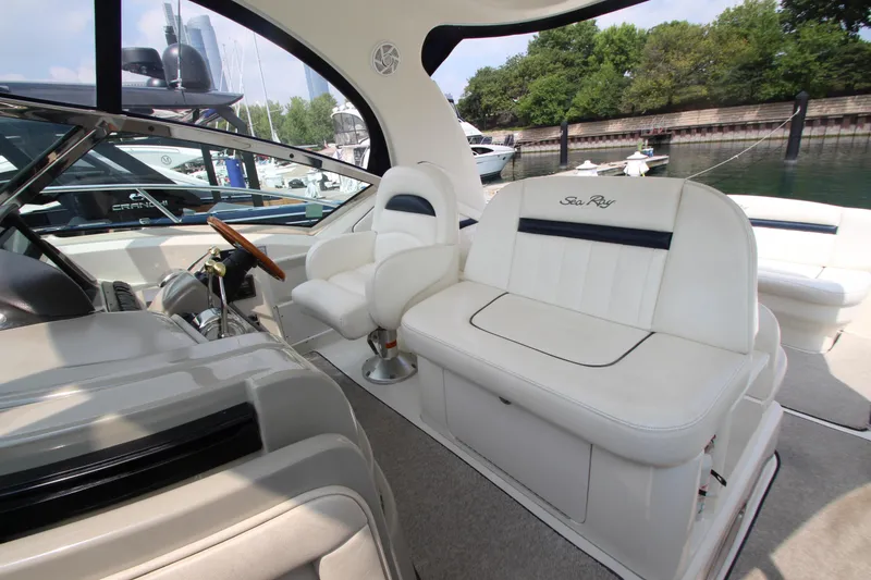 Slide: The Image of Interior of 2004 Sea Ray 40 Sundancer yacht with white seating and steering wheel. - 27