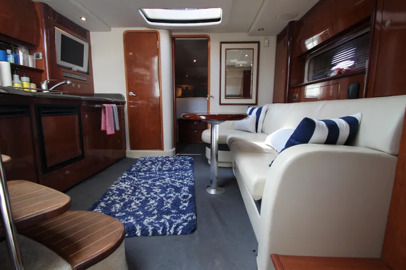 Slide: The Image of Interior of 2004 Sea Ray 40 Sundancer yacht with modern furnishings and cozy seating area. - 34