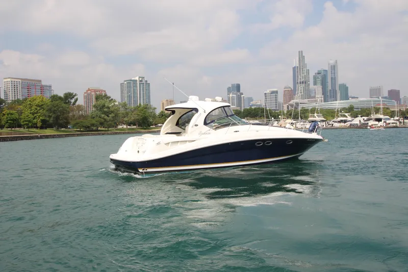 Slide: The Image of 2004 Sea Ray 40 Sundancer yacht cruising near city skyline and marina. - 5