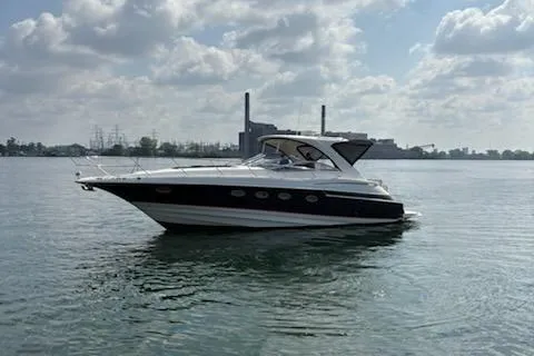 The Image of 2006 Regal Commodore 4460 yacht on calm water under cloudy sky. - 0