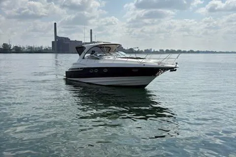 Slide: The Image of 2006 Regal Commodore 4460 yacht on calm water with industrial backdrop. - 1