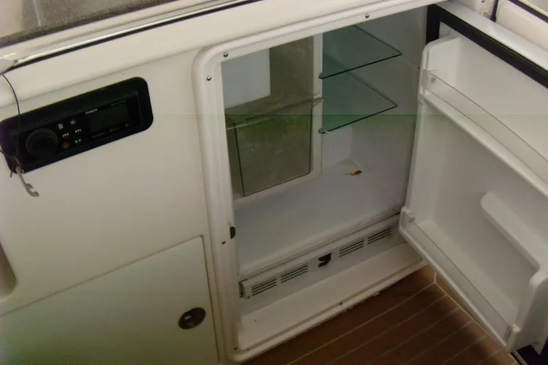 Slide: The Image of 2006 Regal Commodore 4460 boat interior with open refrigerator and control panel. - 16
