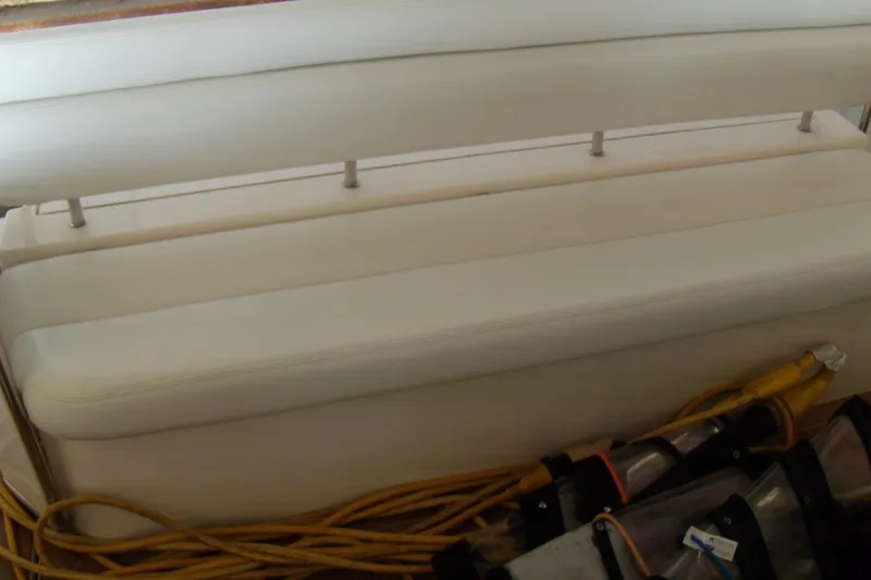 Slide: The Image of 2006 Regal Commodore 4460 boat interior with white seating and coiled cables. - 17