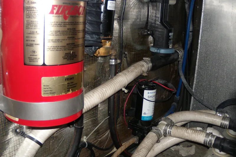 Slide: The Image of Engine room of 2006 Regal Commodore 4460 with fire extinguisher and plumbing components. - 24