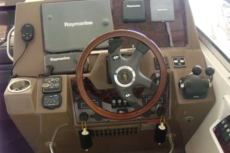 Slide: The Image of 2006 Regal Commodore 4460 helm with Raymarine electronics and wooden steering wheel. - 33