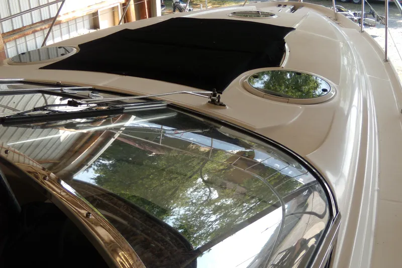 Slide: The Image of 2006 Regal Commodore 4460 yacht with sleek design and reflective windows in a dock setting. - 55