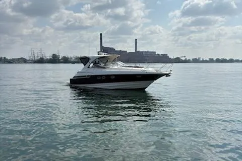 Slide: The Image of 2006 Regal Commodore 4460 yacht on calm water with industrial skyline. - 7