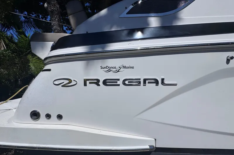 Slide: The Image of 2015 Regal 28 Express boat with SunDance Marine logo, side view. - 12