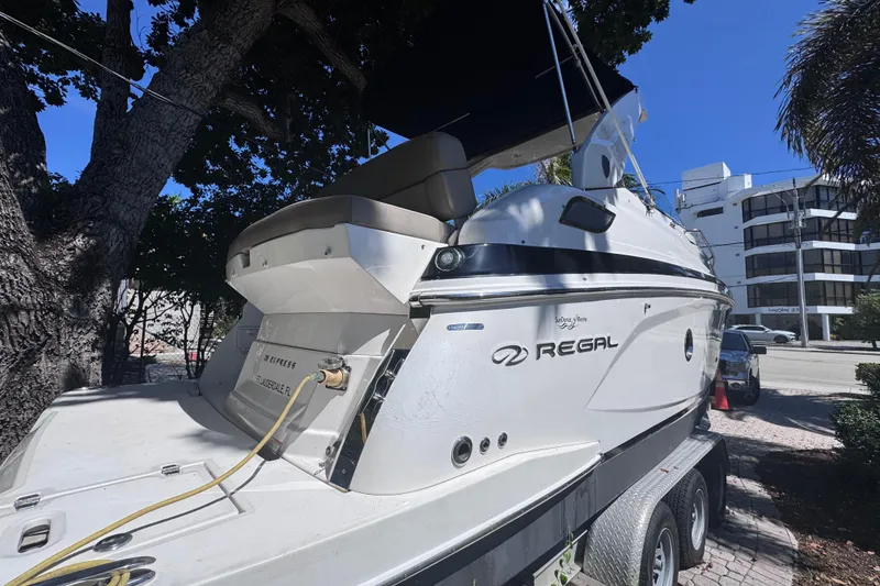 Slide: The Image of 2015 Regal 28 Express boat on trailer, parked under trees, sunny day. - 14