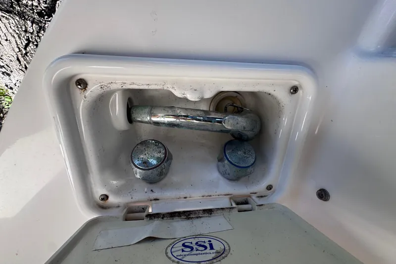 Slide: The Image of 2015 Regal 28 Express boat faucet and controls in a white compartment. - 16