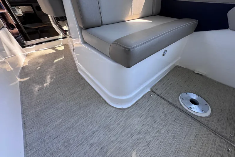 Slide: The Image of Interior of 2015 Regal 28 Express boat with cushioned seating and carpeted flooring. - 17