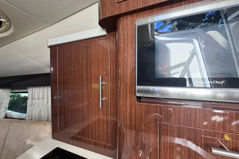 Slide: The Image of Interior of 2015 Regal 28 Express boat with wood cabinetry and microwave. - 25