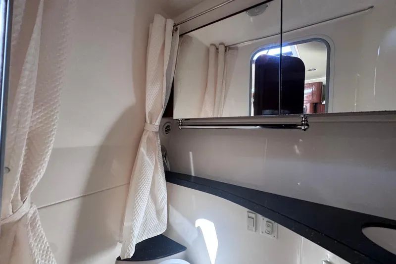 Slide: The Image of 2015 Regal 28 Express boat interior bathroom with mirror and curtain. - 27