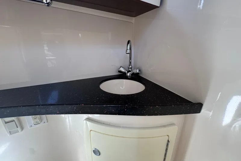 Slide: The Image of 2015 Regal 28 Express boat interior with sleek black countertop and modern sink. - 28