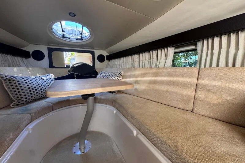 Slide: The Image of 2015 Regal 28 Express cabin interior with seating, table, and porthole window. - 33