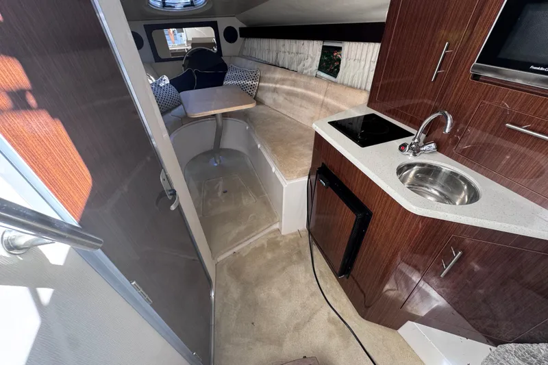 Slide: The Image of 2015 Regal 28 Express cabin interior with kitchenette, seating, and table. - 35