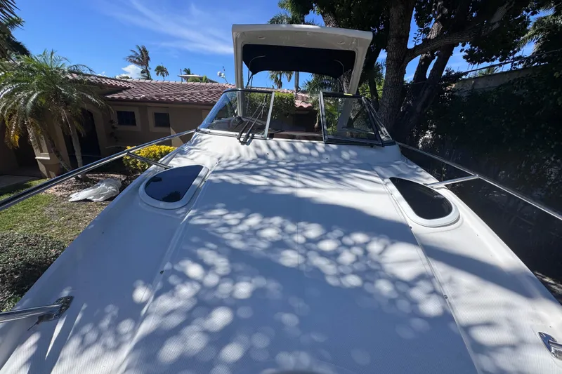 Slide: The Image of 2015 Regal 28 Express boat with sunlit deck, surrounded by tropical foliage. - 38