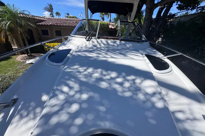 Slide: The Image of 2015 Regal 28 Express boat deck with sunlit patterns and surrounding greenery. - 39