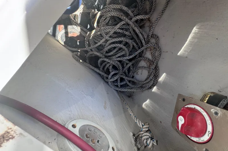 Slide: The Image of Coiled rope and control switch inside 2015 Regal 28 Express boat compartment. - 40