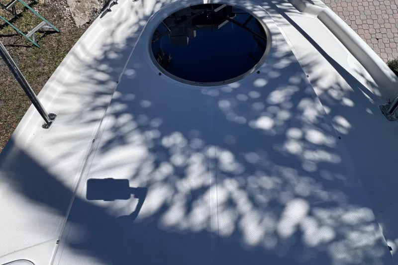 Slide: The Image of 2015 Regal 28 Express boat deck with circular hatch and tree shadows. - 42