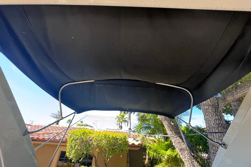 Slide: The Image of 2015 Regal 28 Express boat canopy with lush greenery and clear sky background. - 46