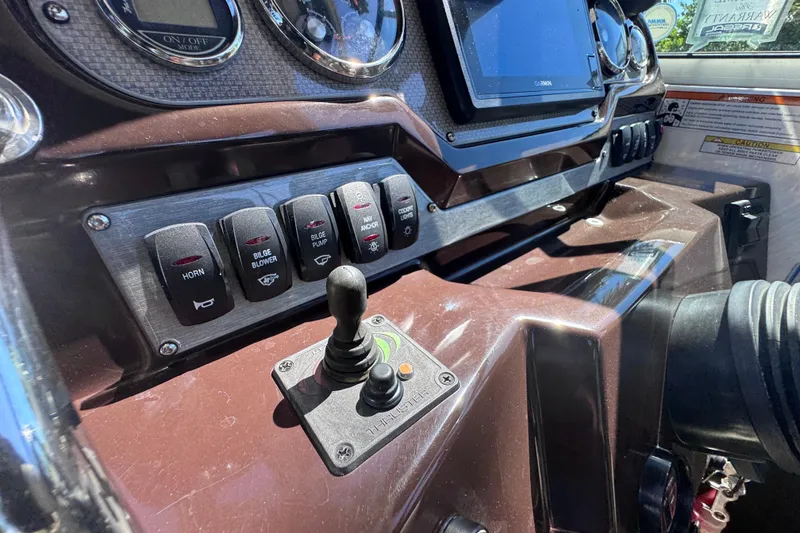 Slide: The Image of Control panel of a 2015 Regal 28 Express boat with switches and joystick. - 52