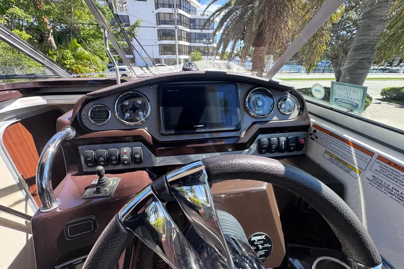 Slide: The Image of Cockpit view of a 2015 Regal 28 Express boat with steering wheel and control panel. - 53