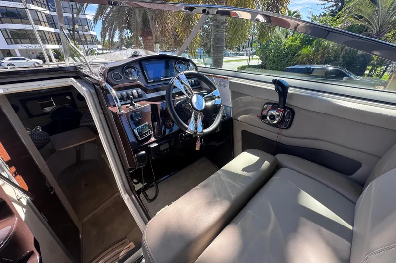 Slide: The Image of 2015 Regal 28 Express boat interior with steering wheel and control panel. - 58