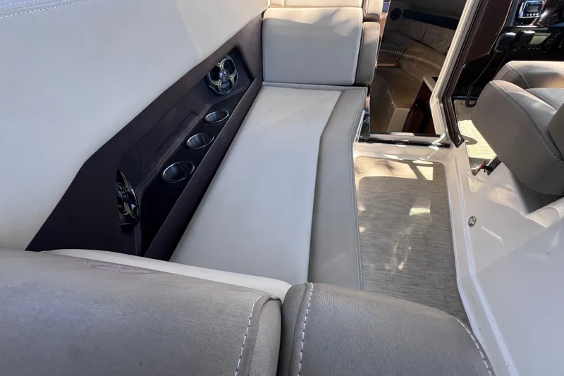 Slide: The Image of Interior of a 2015 Regal 28 Express boat, featuring seating and cup holders. - 61