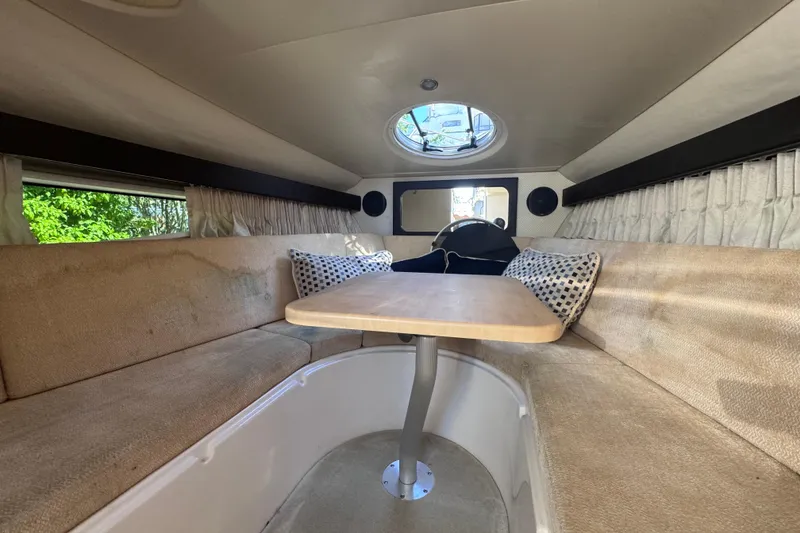 Slide: The Image of 2015 Regal 28 Express cabin interior with seating and table, featuring a circular window. - 70