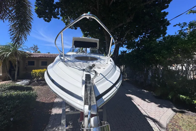 Slide: The Image of 2015 Regal 28 Express boat on trailer, surrounded by trees and a house. - 8