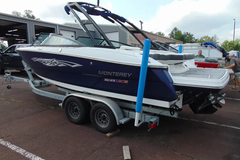 Slide: The Image of 2015 Monterey 238SS boat on trailer, parked outdoors near a garage. - 3