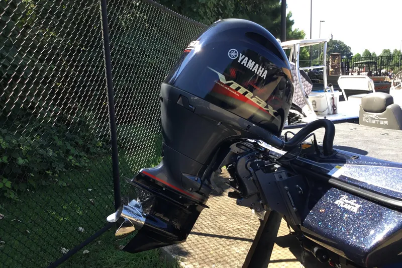 Slide: The Image of 2024 Skeeter ZX 150 boat with Yamaha VMAX outboard motor, parked near a chain-link fence. - 11