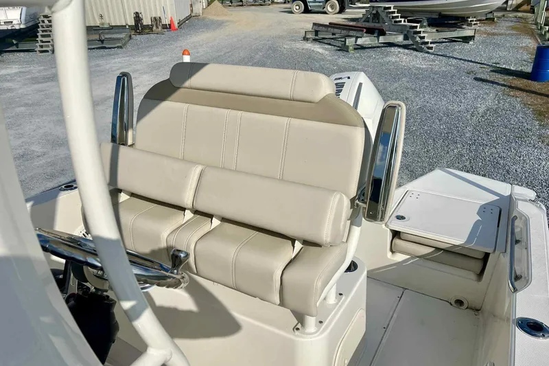 Slide: The Image of 2024 Boston Whaler 220 Dauntless boat interior with beige seating and steering wheel. - 11