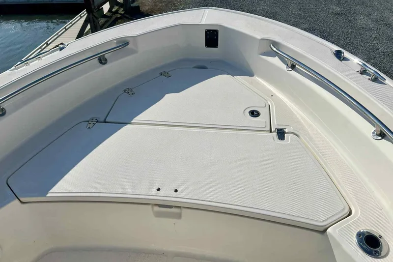 Slide: The Image of 2024 Boston Whaler 220 Dauntless boat deck with storage compartments and stainless steel railings. - 3