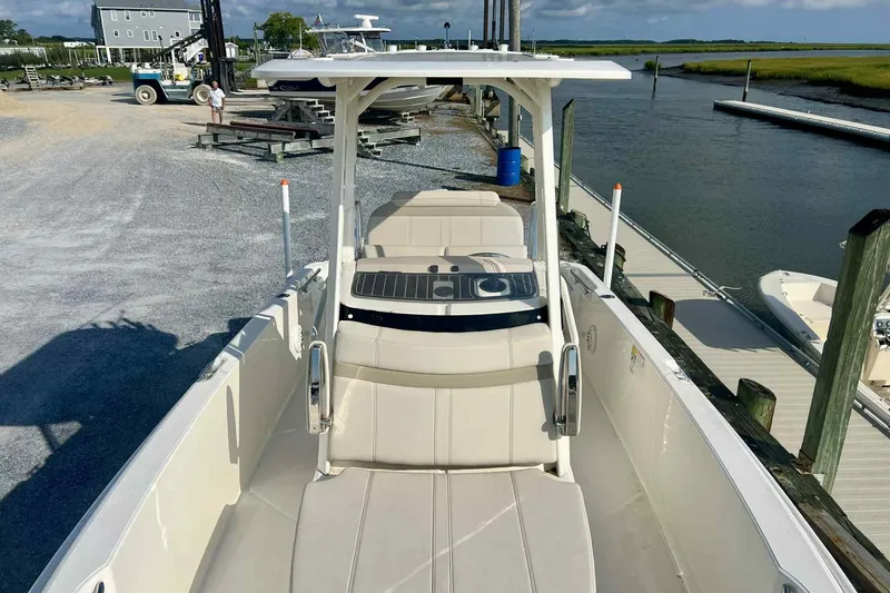 Slide: The Image of 2024 Boston Whaler 220 Dauntless boat docked by a serene waterfront. - 4