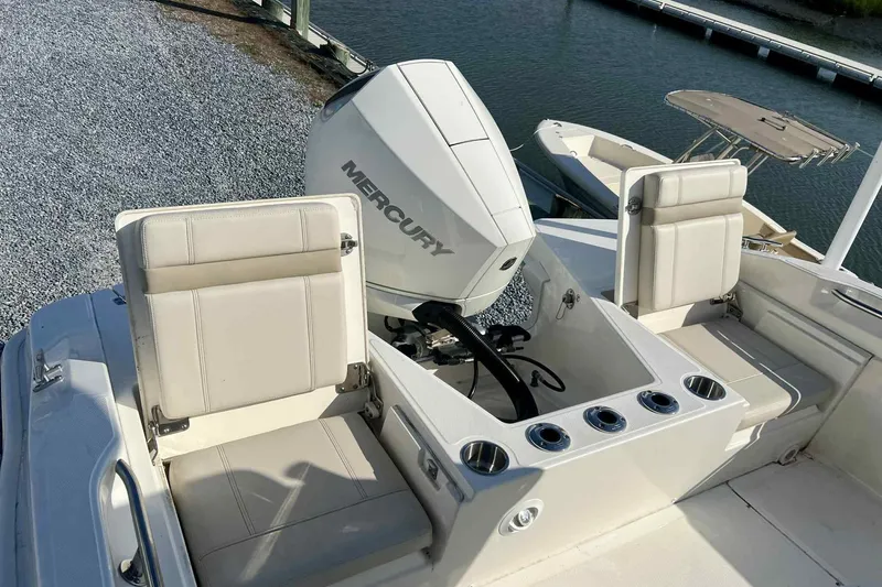 Slide: The Image of 2024 Boston Whaler 220 Dauntless boat with Mercury engine, featuring comfortable seating and cup holders. - 6