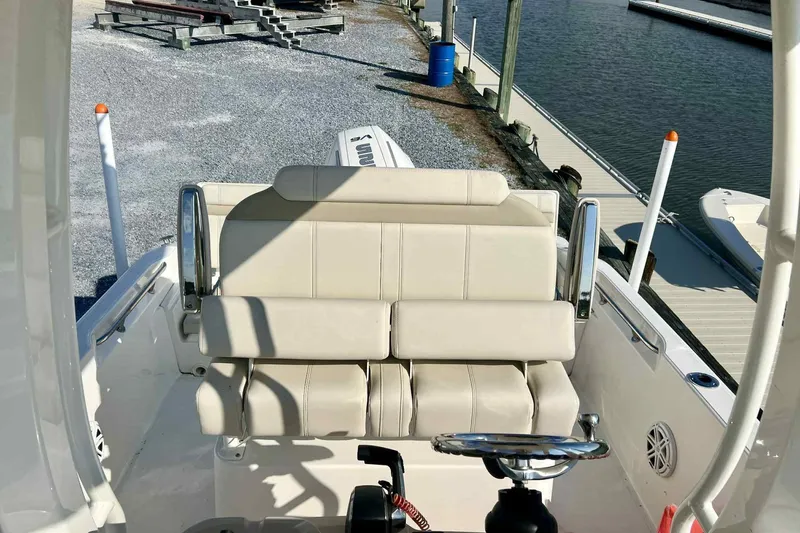 Slide: The Image of 2024 Boston Whaler 220 Dauntless boat interior with beige seating and steering wheel. - 9
