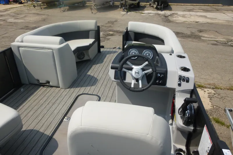 Slide: The Image of 2025 Harris boat interior with steering wheel, dashboard, and seating on a wooden deck. - 3