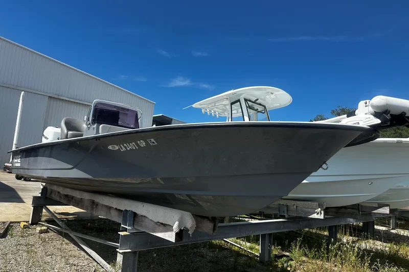 Slide: The Image of 2022 Haynie 25 Magnum boat on display, gray hull, outdoor setting, clear blue sky. - 10