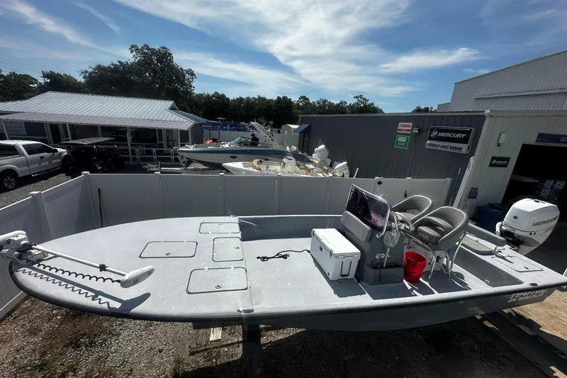Slide: The Image of 2022 Haynie 25 Magnum boat at a marine dealership, featuring a spacious deck and modern equipment. - 3