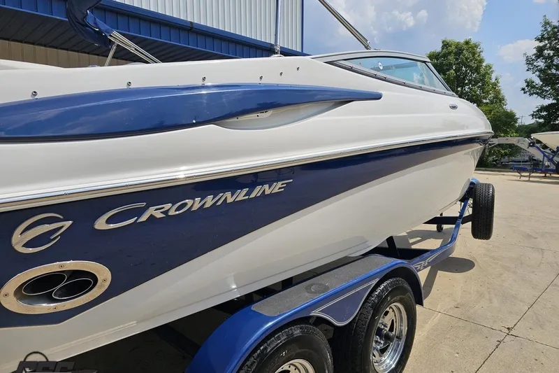 Slide: The Image of 2007 Crownline 23 SS boat on trailer, blue and white design, parked outdoors. - 10