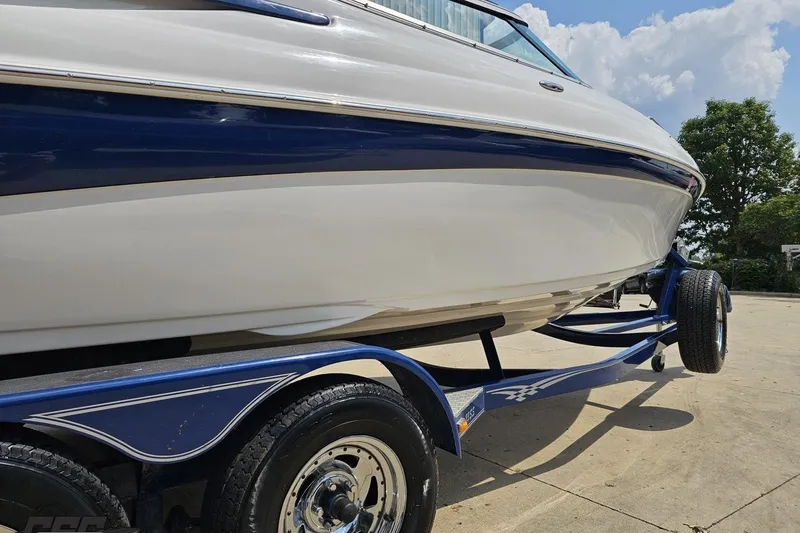 Slide: The Image of 2007 Crownline 23 SS boat on trailer, blue and white design, sunny day. - 11