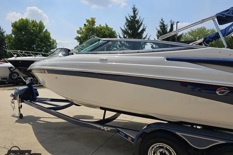 Slide: The Image of 2007 Crownline 23 SS boat on trailer, parked outdoors under a clear sky. - 23