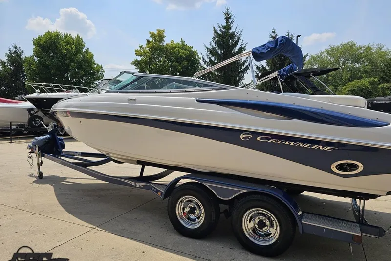 Slide: The Image of 2007 Crownline 23 SS boat on trailer, parked outdoors under a clear sky. - 24