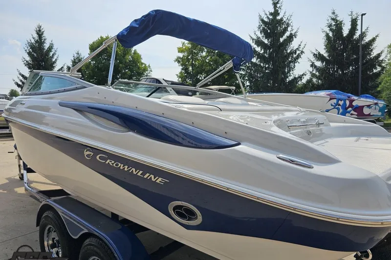 Slide: The Image of 2007 Crownline 23 SS boat with blue accents on a trailer, outdoors. - 26